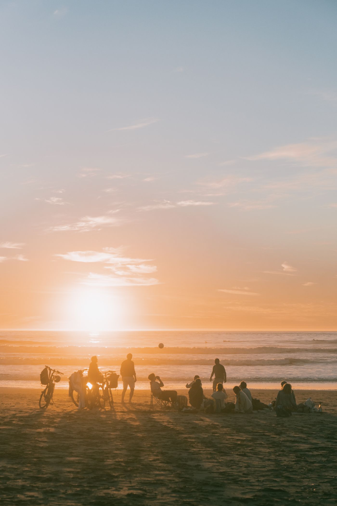 Un groupe de voyageurs réunis sur la plage au coucher du soleil